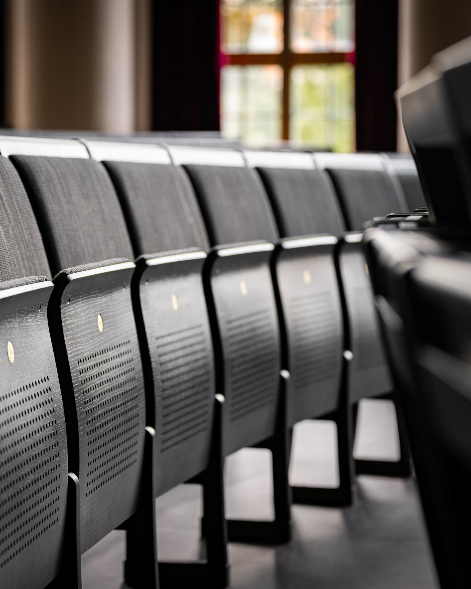 Rows of auditorium chairs in the Stockholm School of Economics Aula