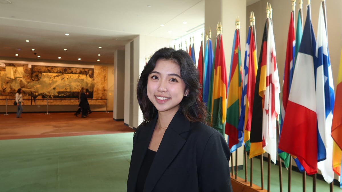 Katarina Li Qiu standing in front of a row of international flags