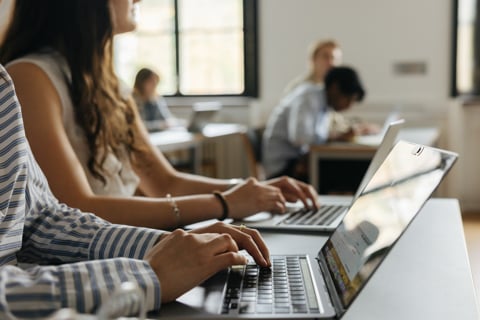 Hands typing on a laptop keyboard