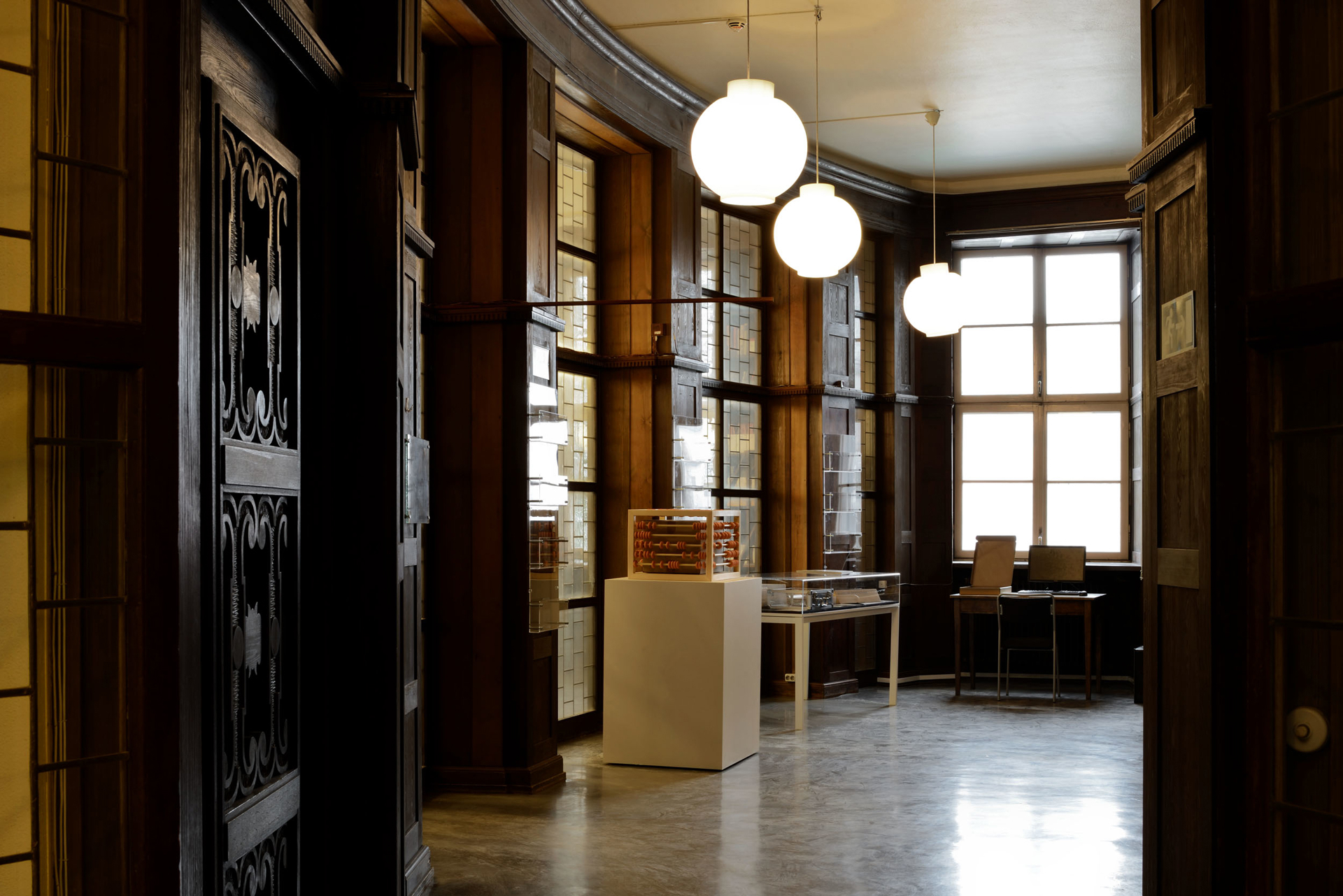 A wood-panelled interior with globe pendant lights at the Stockholm School of Economics