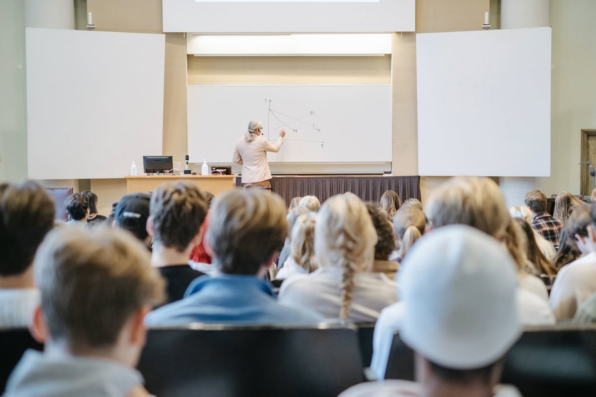 A lecturer writing on a whiteboard in a lecture hall at the Stockholm School of Economics