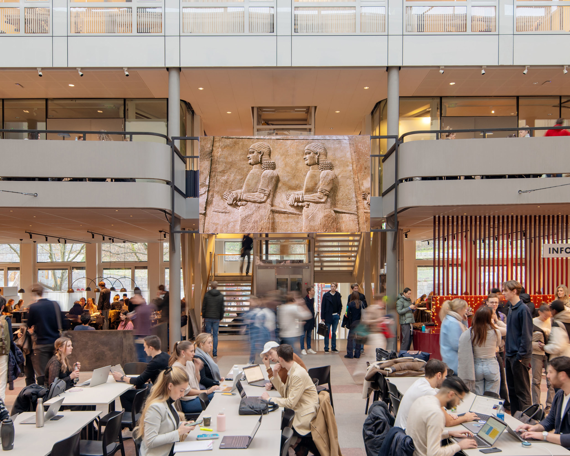 Students working beneath a hanging artwork in the SSE atrium